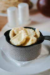 Russian dumplings vareniki in ceramic bowl at cafe.