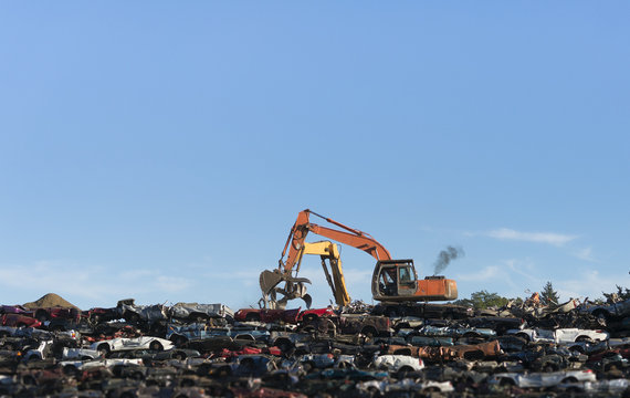 Excavators stacking cars for scrap.
