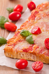 Italian pizza with cheese, tomatoes and fresh basil.