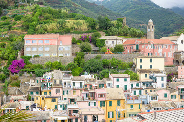 View to city, belltower of the church Santa Margherita and green mountains of Vernazza, Cinque Terre, Italy