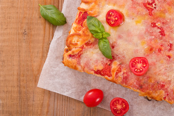 Italian pizza with cheese, tomatoes and fresh basil.