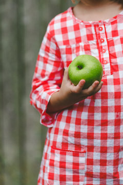 Young girl holding green apple