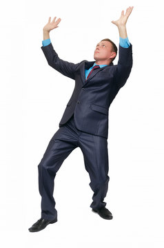A young business man stands on bent knees and holds his hands above his head as if he is carrying something or holding it, isolated on white background.