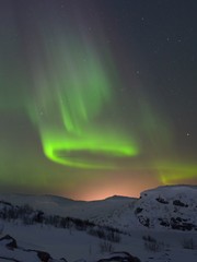 Snow covered the hills and in the sky stars, clouds and northern lights.