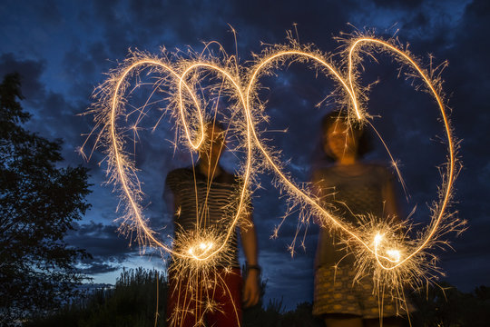 Romantic heart shapes created by sparklers in summer