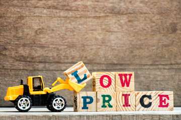 Toy plastic bulldozer hold letter block L to complete wording hot price on wood background © bankrx