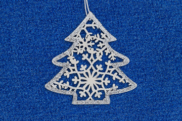 Christmas fashion background with wooden openwork Christmas tree on denim blue fabric