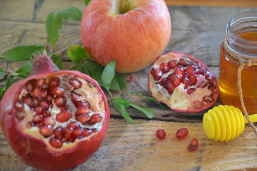 Honey, apple and pomegranate for traditional holiday symbols rosh hashanah jewesh holiday on wooden background