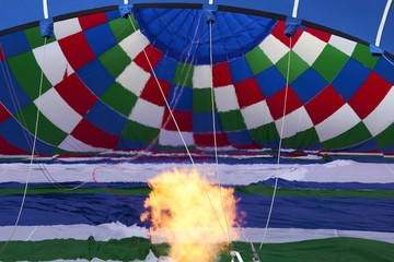 Obraz premium A burner with its super hot flame light up inside of a hot air balloon as it is inflated for an flight.