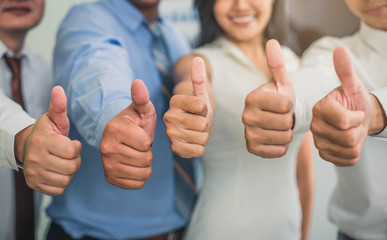 Cheerful business group giving thumbs up. Group of happy multiracial businesspeople gesturing thumb...