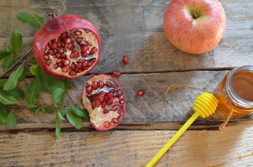 Honey, apple and pomegranate for traditional holiday symbols rosh hashanah (jewesh holiday) on black background