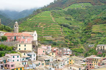 Fototapeta premium View to city, belltower and green mountains of Vernazza, Cinque Terre, Italy