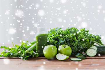 close up of bottle with green juice and vegetables
