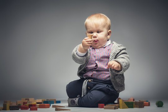 Baby boy examining a building block.