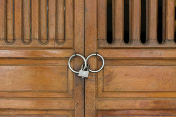 Lock the wooden door. Design of vintage handle and locked on wood door.