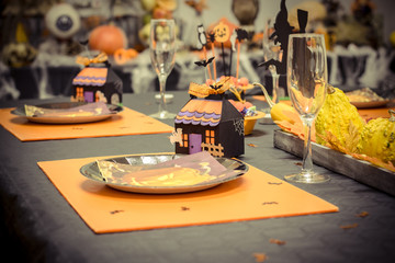 une table de réception avec de la décoration pour la fête d'halloween, des verres et des...