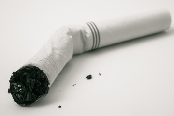 Obraz premium Cigarette butt with ash on a white background.