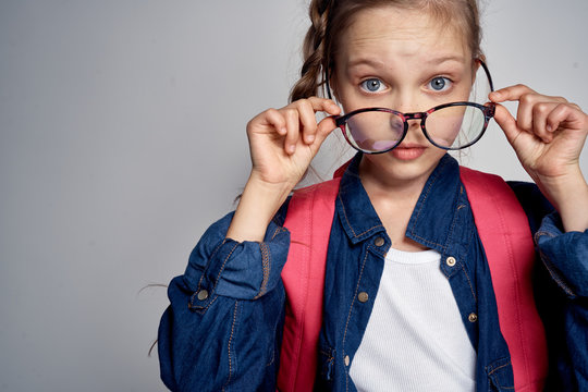 schoolgirl takes off big glasses and looks closely