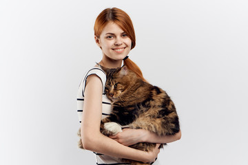 red-haired girl hugging a large fluffy cat