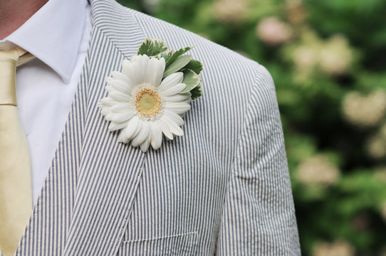 Close up of a grooms suit boutonniere