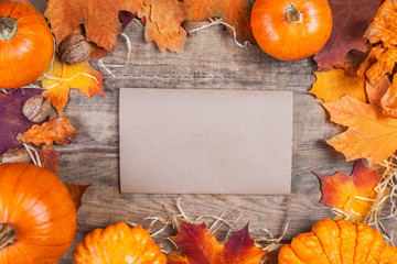 Thanksgiving Day concept -  border or frame with orange pumpkins and colourful leaves on wooden...