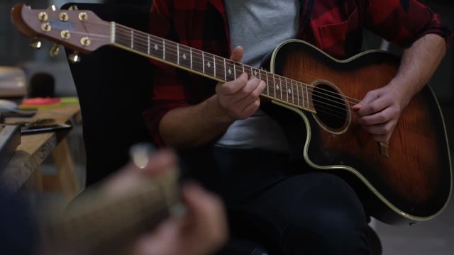  Close up on hands 2 unrecognizable guitarists playing together