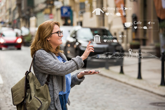 Augmented reality in marketing. Woman traveler with phone. Navigation on the projection of the display