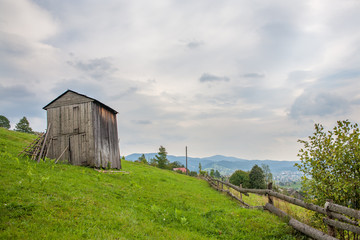 barn on green grass in the mountains