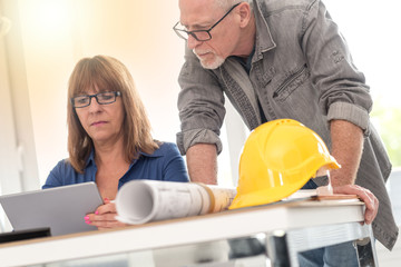 Architects working on plans, light effect