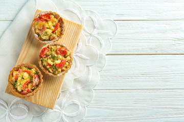 Delicious crispy tarts with broccoli on wooden board