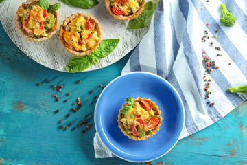 Delicious crispy tarts with broccoli on table