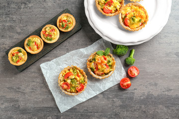 Delicious crispy tarts with broccoli on table