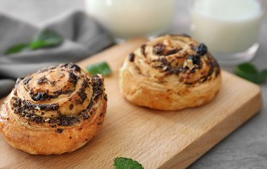 Tasty pastry with poppy seeds on wooden board