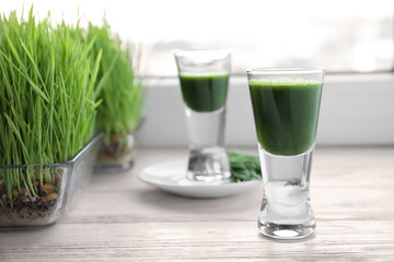 Shot of wheat grass juice on window sill