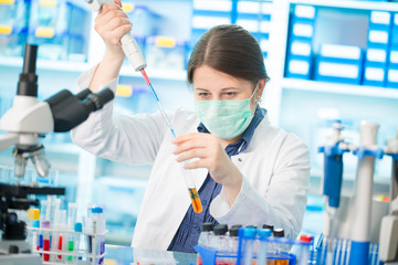 Girl laboratory assistant in the chemical laboratory of the university experiment with chemical reagents