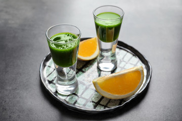 Shots of healthy wheat grass juice on plate