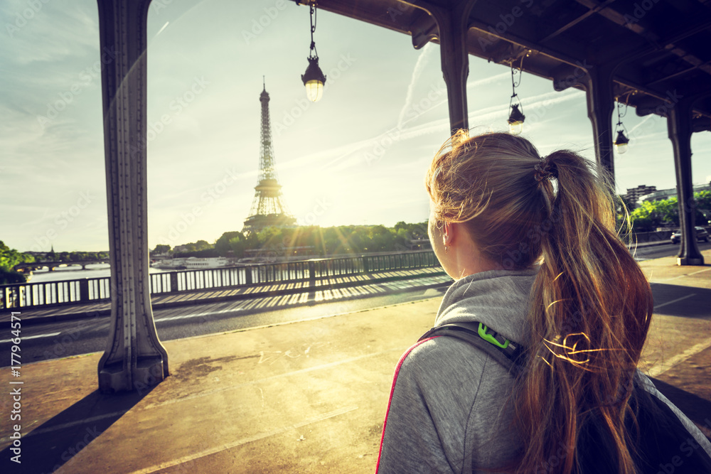 Wall mural woman tourist in front of the Eiffel Tower in Paris, France