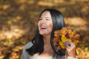 Happy woman enjoying autumn day in the park, selective focus 