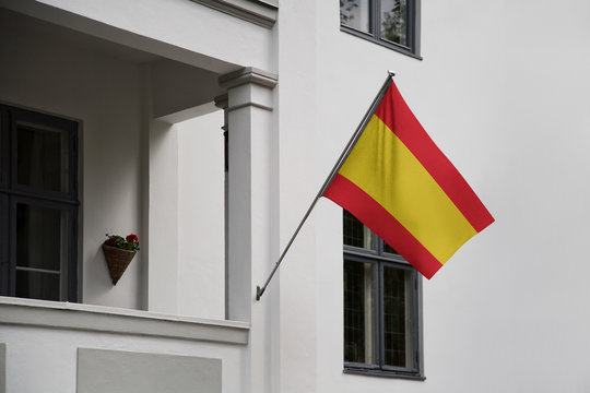 Spain flag. Spanish flag displaying on a pole in front of the house. National flag of Spain Espana waving on a home hanging from a pole on a front door of a building.