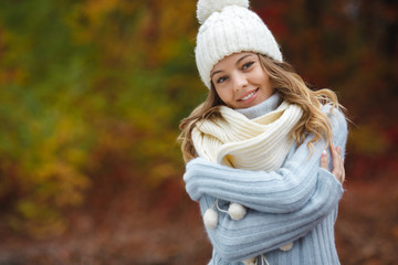 Very beautiful young woman on the autumn background. Close up portrait of smiling young pretty girl in the fall time.