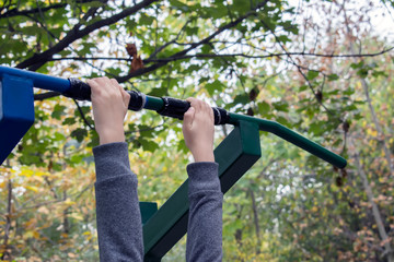 Girl exercising at outdoors gym playground equipment