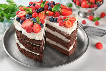 Delicious chocolate cake with berries on table