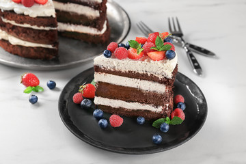 Plate with piece of delicious chocolate cake on table