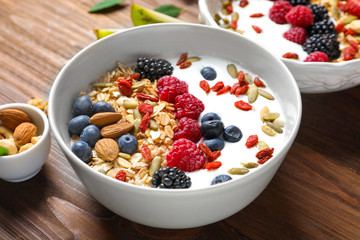 Tasty breakfast with goji berries in bowl on table