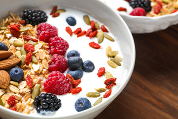 Tasty breakfast with goji berries in bowl on table