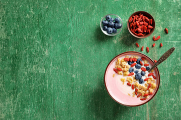 Tasty breakfast with goji berries in bowl on table