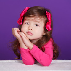 Young brunette dolly lady girl stylish dressed in pink shirt with flowers smiling posing sitting in studio with pout lips and pink cheeks.