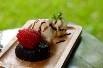 Chocolate Lava cake Served with Strawberry and Vanilla ice cream whipping cream set on wooden tray in summer time with day light. Have some space for write wording