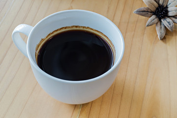 Coffee cup on a wooden table, selective focus (detailed close-up shot)