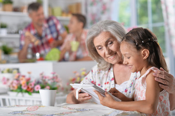  girl with grandmother using tablet